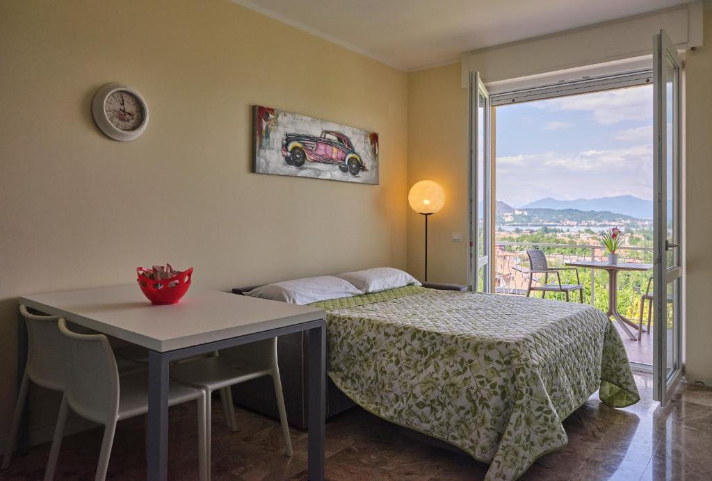 アローナにあるCasa Ierardi - Appartamento Arona Bellavistaのベッドルーム1室(ベッド1台、テーブル、窓付)
