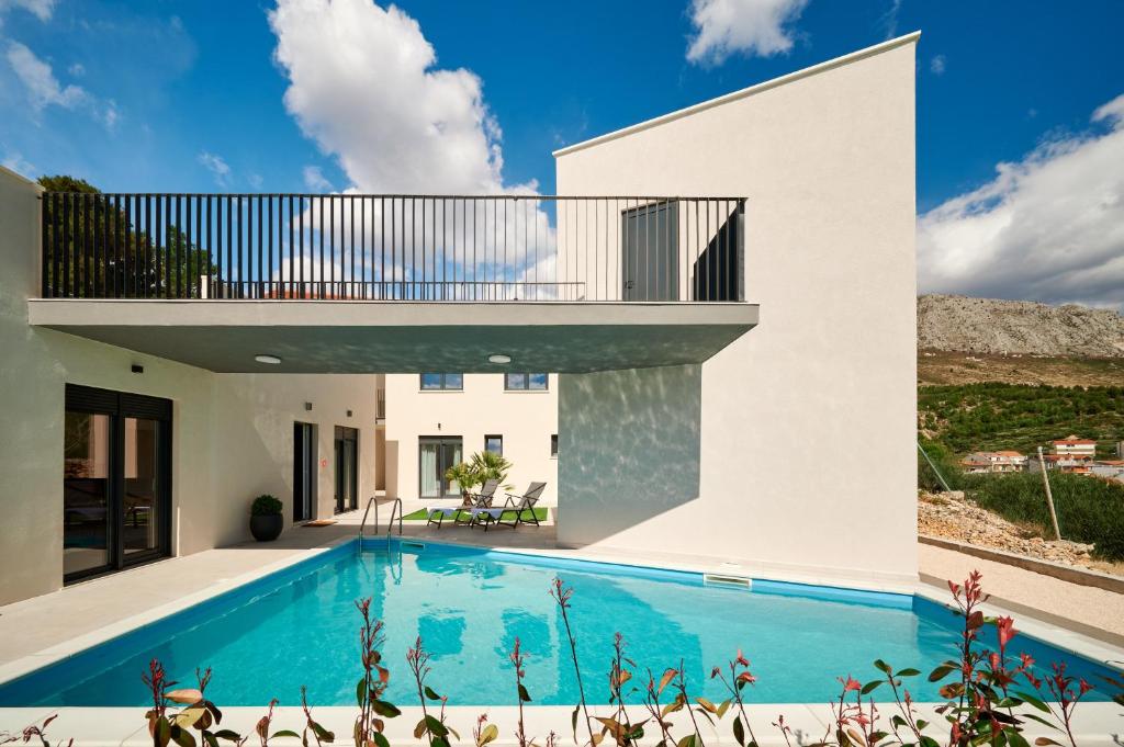 une maison avec une piscine et un balcon dans l'établissement Luxury villa with a swimming pool Rat, Omis - 21548, à Dugi Rat