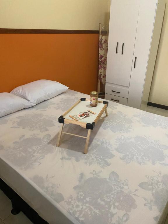 uma cama com uma mesa em cima em Orange House Itaipuaçu em Maricá