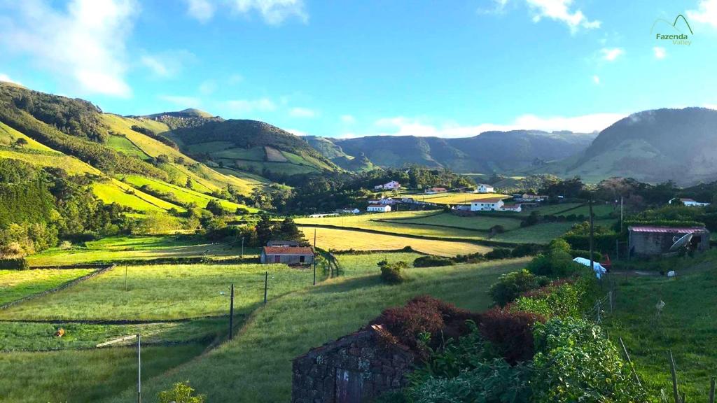 a green field with mountains in the background at Fazenda Valley in Santa Cruz das Flores