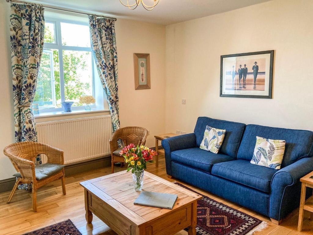 a living room with a blue couch and a table at North Walk House in Lynton