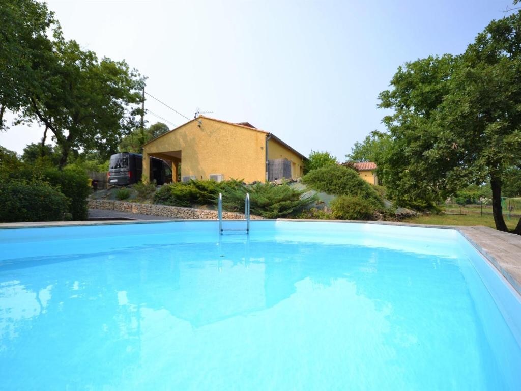 een groot blauw zwembad voor een huis bij Alluring Holiday Home in Largenti re with Pool in Largentière