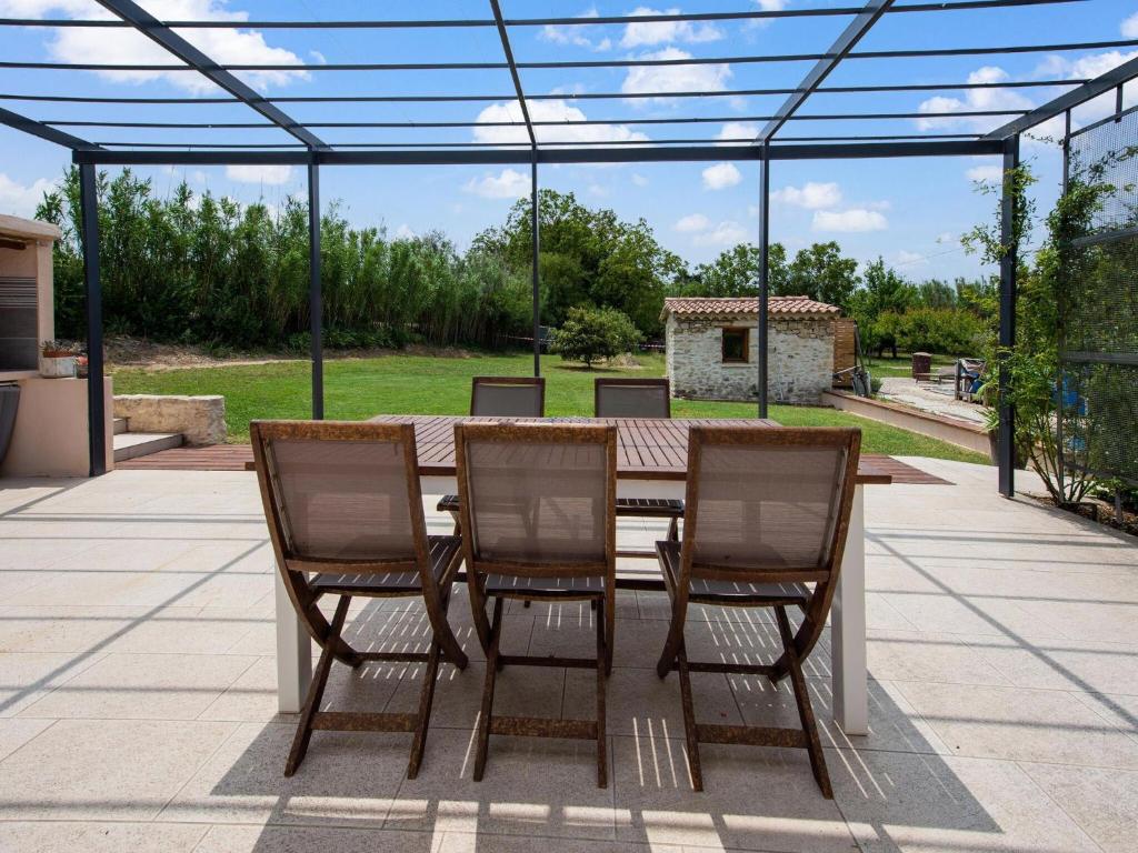 een tafel en stoelen op een patio met een glazen dak bij Saint-Victor House in Pernes-les-Fontaines