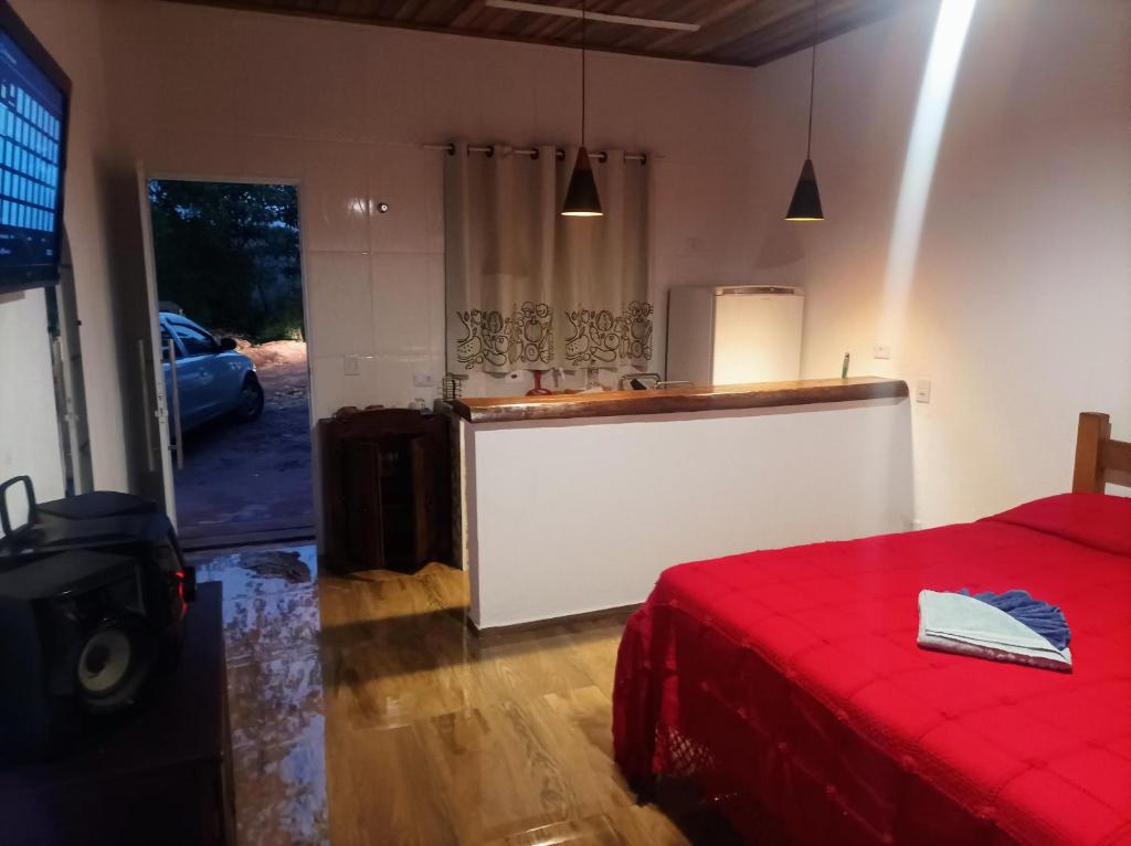 坎普斯杜若爾當的住宿－Styllo Suítes Econômicas，一间带红色床的客厅和一间厨房