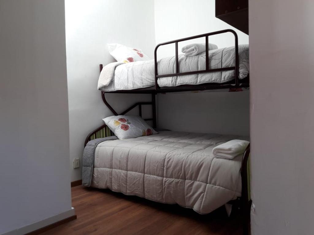 a bedroom with two bunk beds and a small bed at Casa Turistica Las Tunas in Sicuani