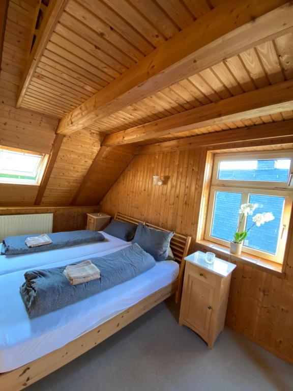 a bedroom in a log cabin with a bed and a window at Attraktiver Luftkurort Winterberg in Winterberg