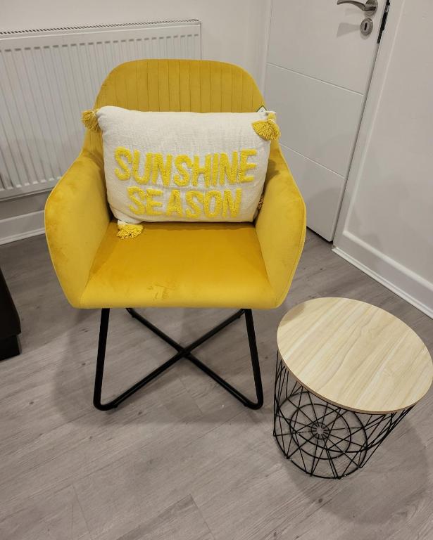 a yellow chair with a pillow that says sunshine season at 3 Bedrooms 2baths 3 toilets Excel City Airport O2 Sleeps up to 7, in London