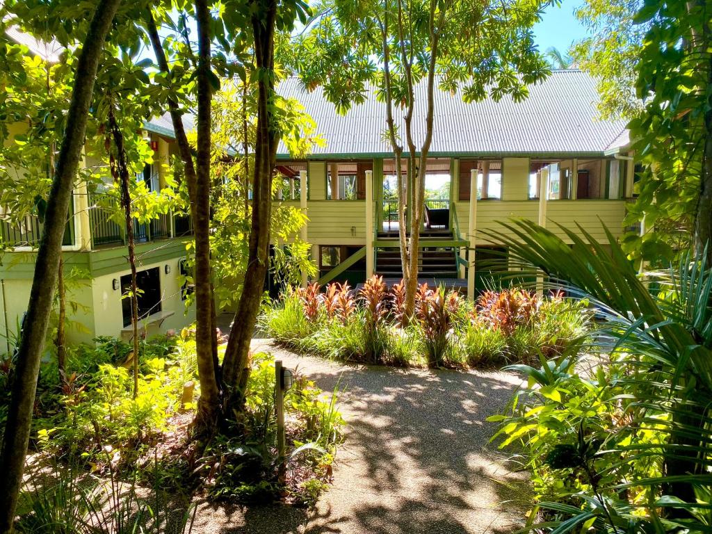Mission Beach的住宿－Jackaroo Treehouse Rainforest Retreat，黄色的房子,前面有一个花园