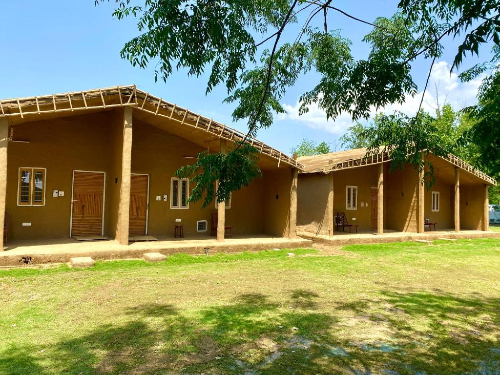 a house with a grass yard in front of it at Virsaa - The Captain's Mud Retreat in Sirhind