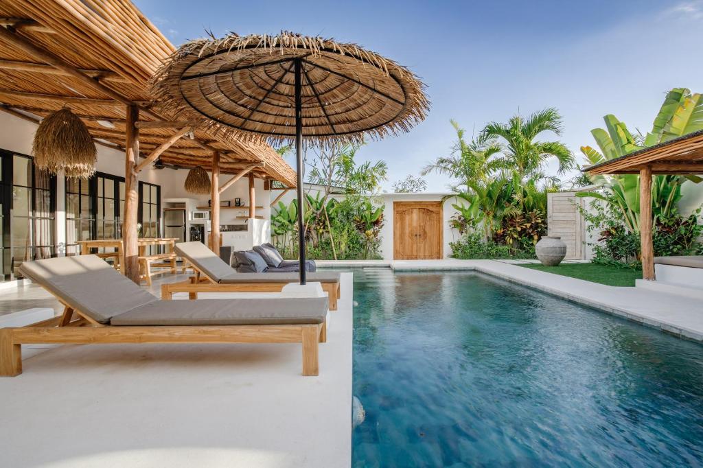 einen Außenpool mit Stühlen und einem Sonnenschirm in der Unterkunft Villa Ruta I - Sumptuous 2BR Private Luxury Villa Walking Distance to Nyanyi Beach in Tanah Lot