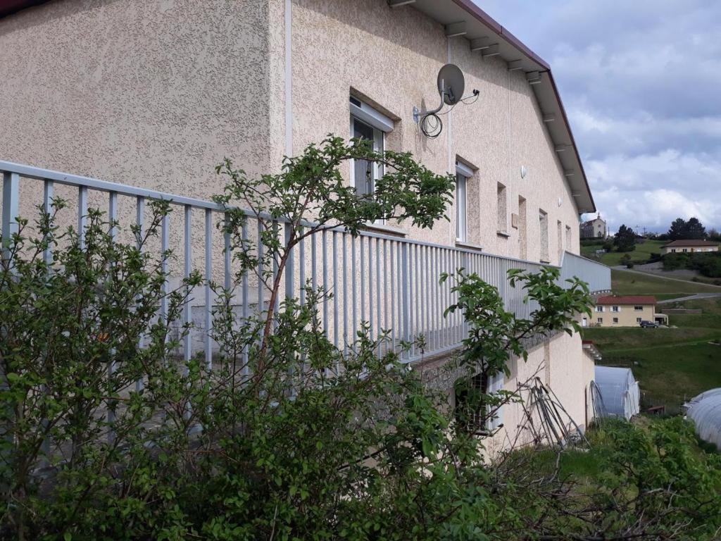 un edificio con una valla en el costado en Gîte Saint-Romain-en-Jarez, 3 pièces, 4 personnes - FR-1-496-295, en Saint-Romain-en-Jarez