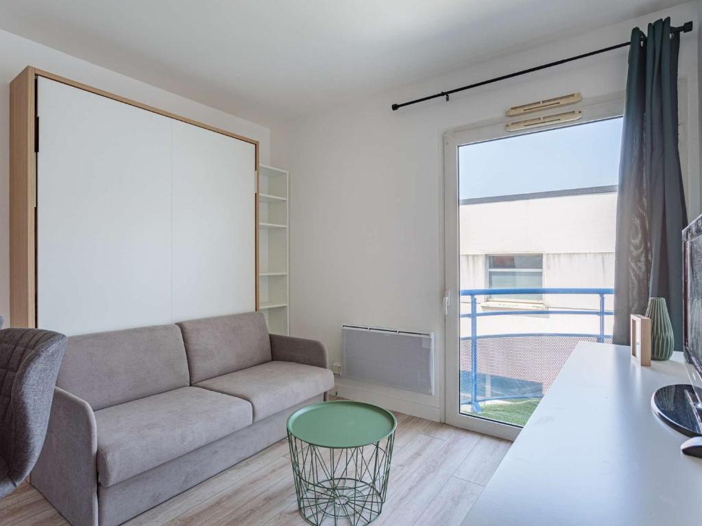 un salon avec un canapé et une table dans l'établissement Studio refait à neuf à Anglet, proche commerces & plages, avec balcon et parking gratuit - FR-1-3-594, à Anglet