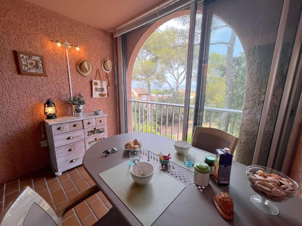 une cuisine avec une table et une grande fenêtre dans l'établissement Appartement avec piscine, tennis, proche plage - 4 personnes - Saint Aygulf - FR-1-226A-161, à Fréjus
