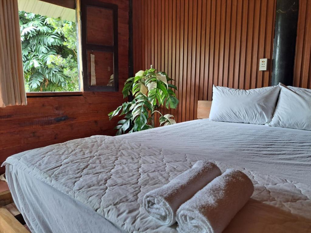 - une chambre avec un lit blanc et des serviettes dans l'établissement Happy Farm Tien Giang Homestay, à Mỹ Tho