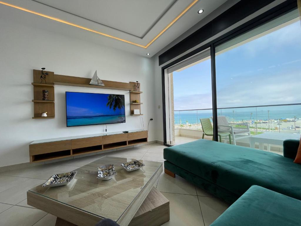 un soggiorno con TV a schermo piatto e divano di Beachfront High Standard Flat a Martil