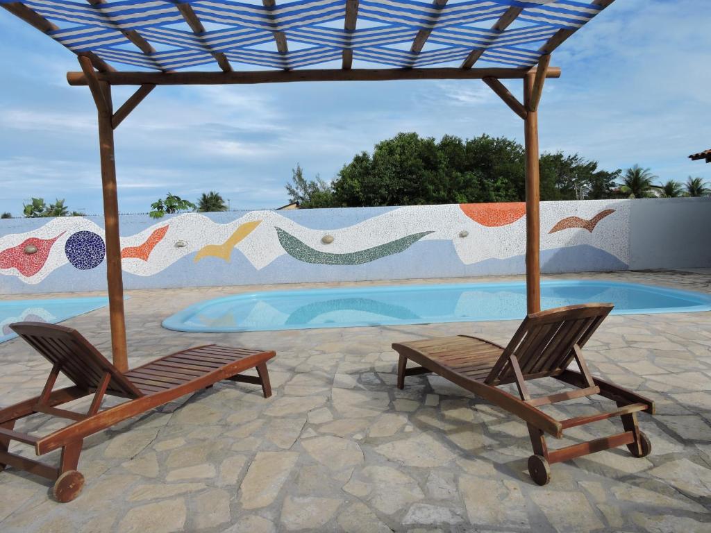 zwei Stühle und ein Sonnenschirm neben einem Pool in der Unterkunft Casabella in Lucena