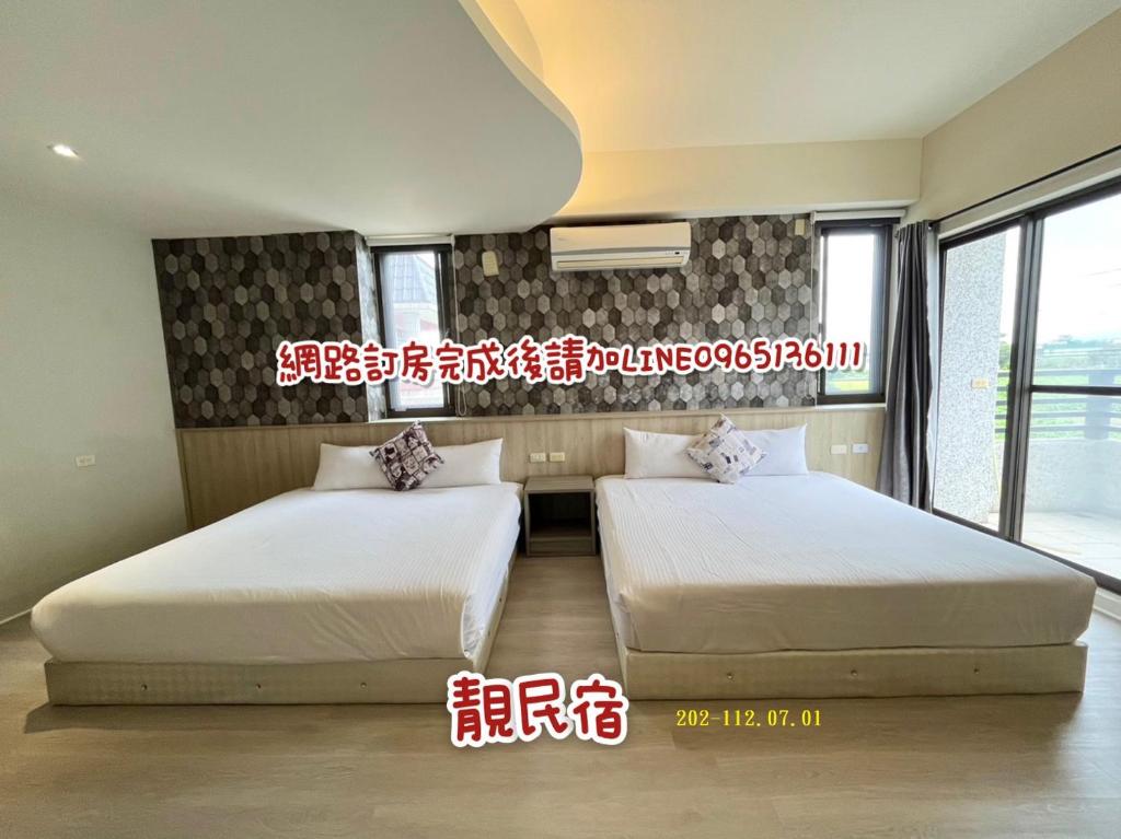 two beds in a room with two windows at 靚民宿-有車位-需付訂金 in Ji'an