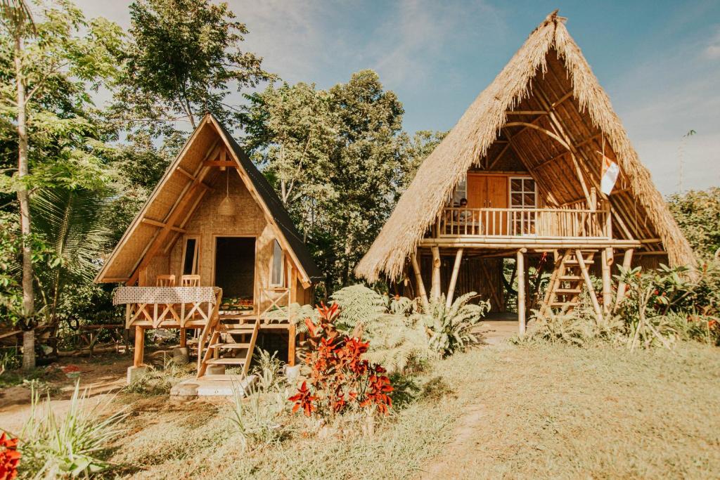a house with a thatch roof and a porch at Girang Rinjani Bungalows in Tetebatu