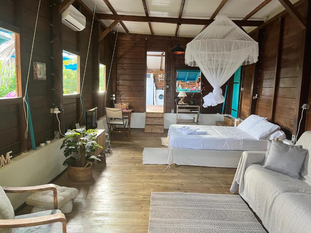 1 dormitorio con 2 camas y sofá en Bungalow avec vue dans lieu calme, en Le Carbet