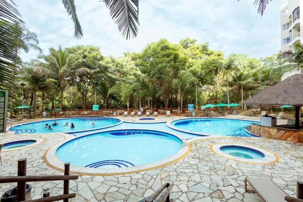 a pool at a resort with people in it at Thermas Paradise - Rio Quente - Apto 2 quartos com Suíte in Rio Quente