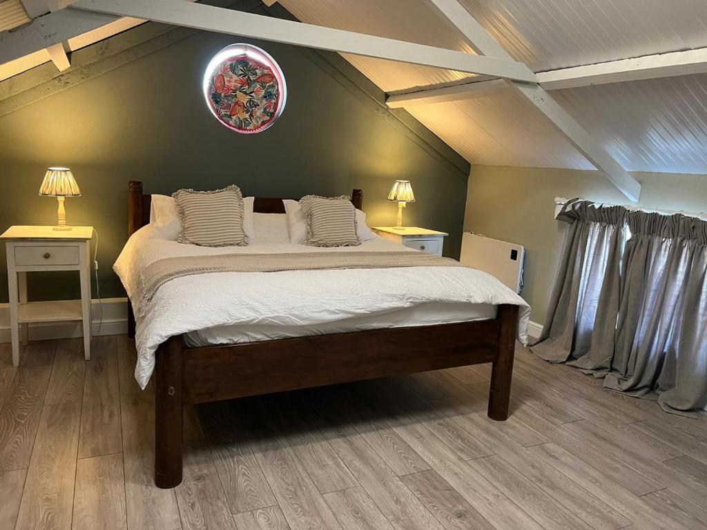 a bedroom with a large bed with white sheets at The Old Water Works - Flat 1 in Wadebridge