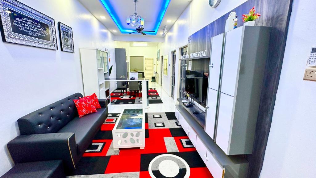 - un salon avec un canapé noir et un tapis rouge dans l'établissement Landed Rayyan Homestay Gong Badak Kuala Nerus Free Wifi Full Aircond, à Kampong Pengkalan Maras