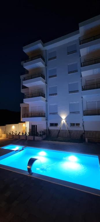 a swimming pool in front of a building at night at Cold Bay Mansion in Bar