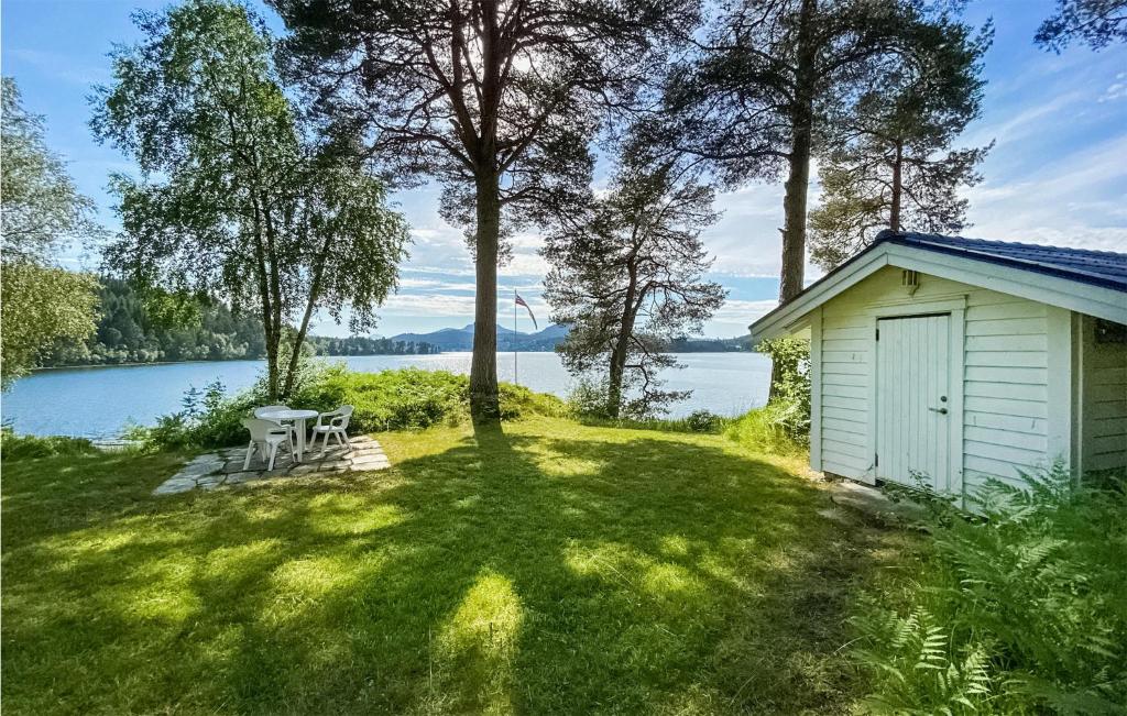 a small shed in the grass next to a lake at Stunning Home In Skodje With Wifi And 4 Bedrooms in Skodje