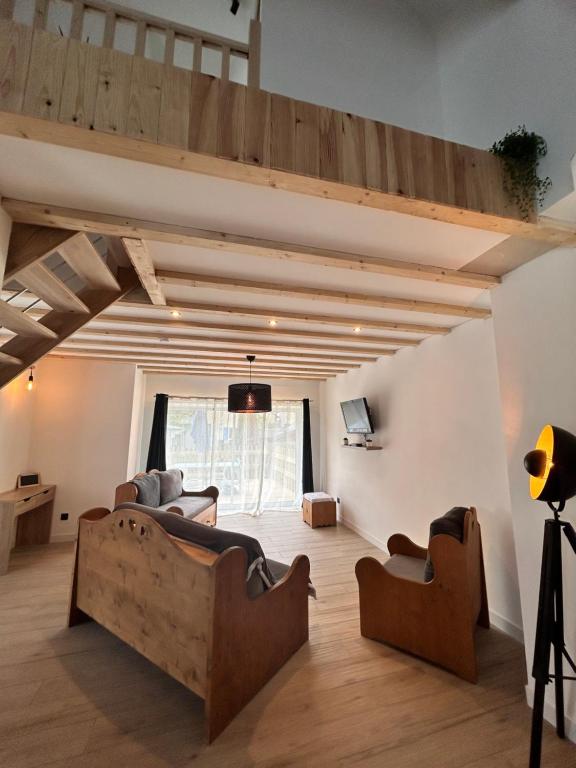un salon avec des canapés et une mezzanine dans l'établissement Entre lacs et montagnes, à La Motte-Saint-Martin