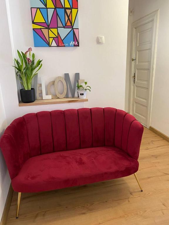 a red couch sitting in a living room at Private room at Ceausescu's place in Old City Unirii Square in Bucharest