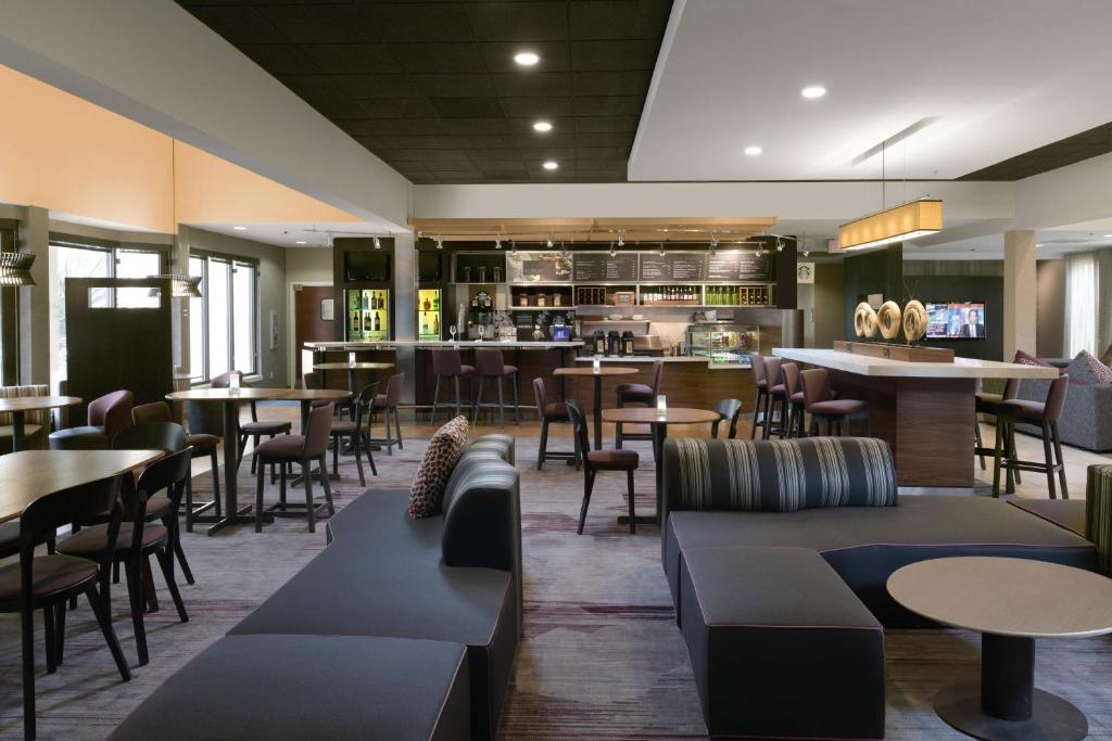 a restaurant with tables and chairs and a bar at Courtyard by Marriott Albuquerque Airport in Albuquerque