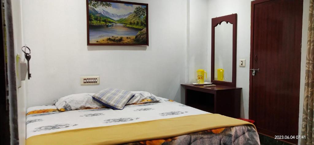 a bedroom with a bed and a picture on the wall at Floral Homestay in Thekkady