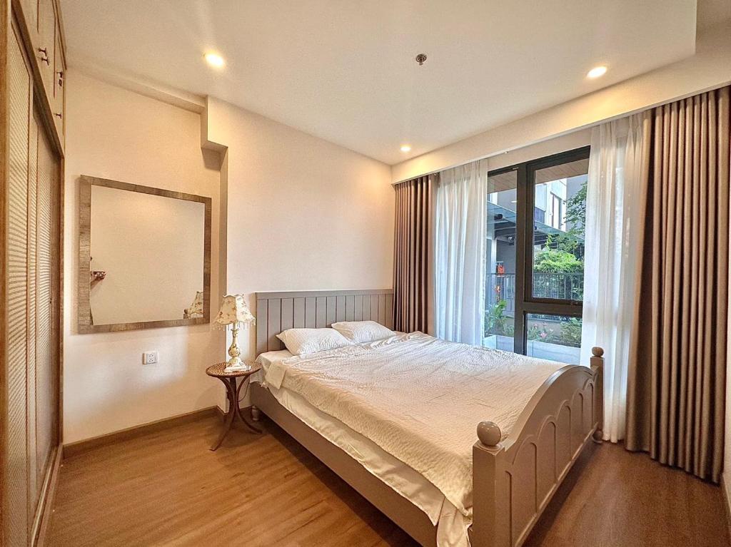 een slaapkamer met een groot bed en een raam bij Homestay Ecopark in Kim Quan