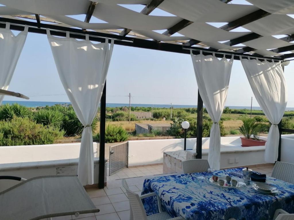 um pátio com uma mesa e vista para o oceano em Villa Meli&Teo em Marina di Pescoluse