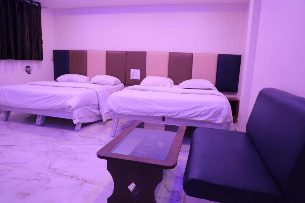 Habitación hospitalaria con 2 camas y mesa en KAPILA RESIDENCY, en Bangalore