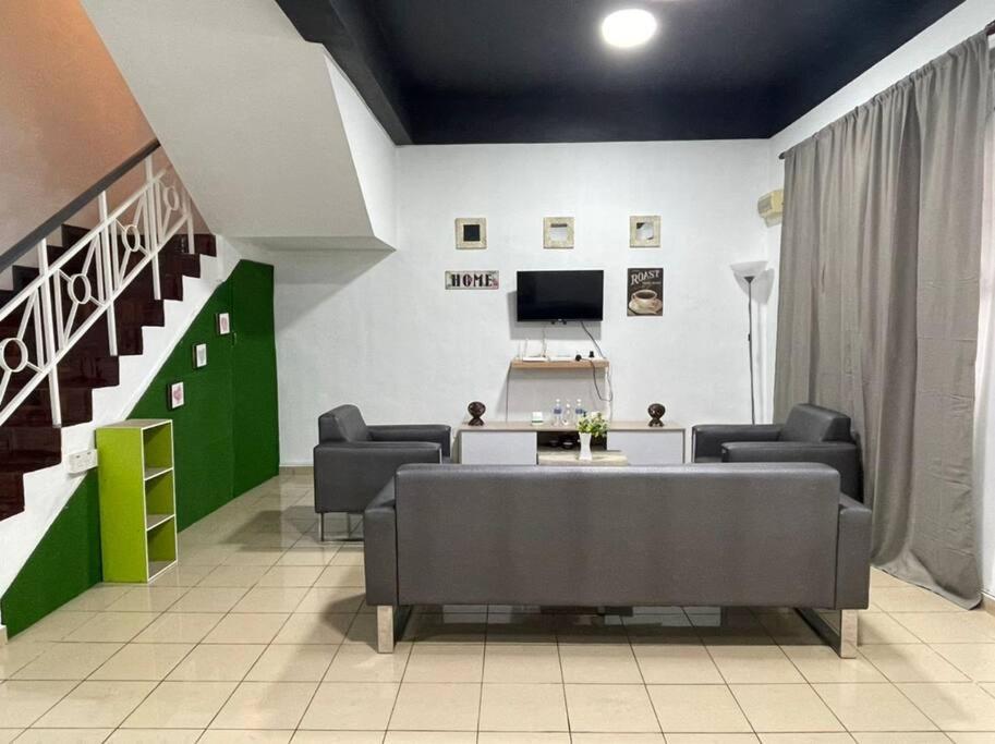 a waiting room with a couch and chairs and a tv at Double Storey terrace house in Sandakan Sabah in Sandakan