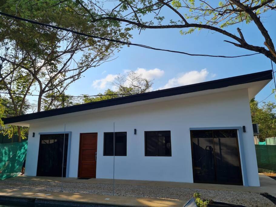 ein weißes Haus mit schwarzem Dach in der Unterkunft Casa Mar de Sueños Tamarindo in Tamarindo