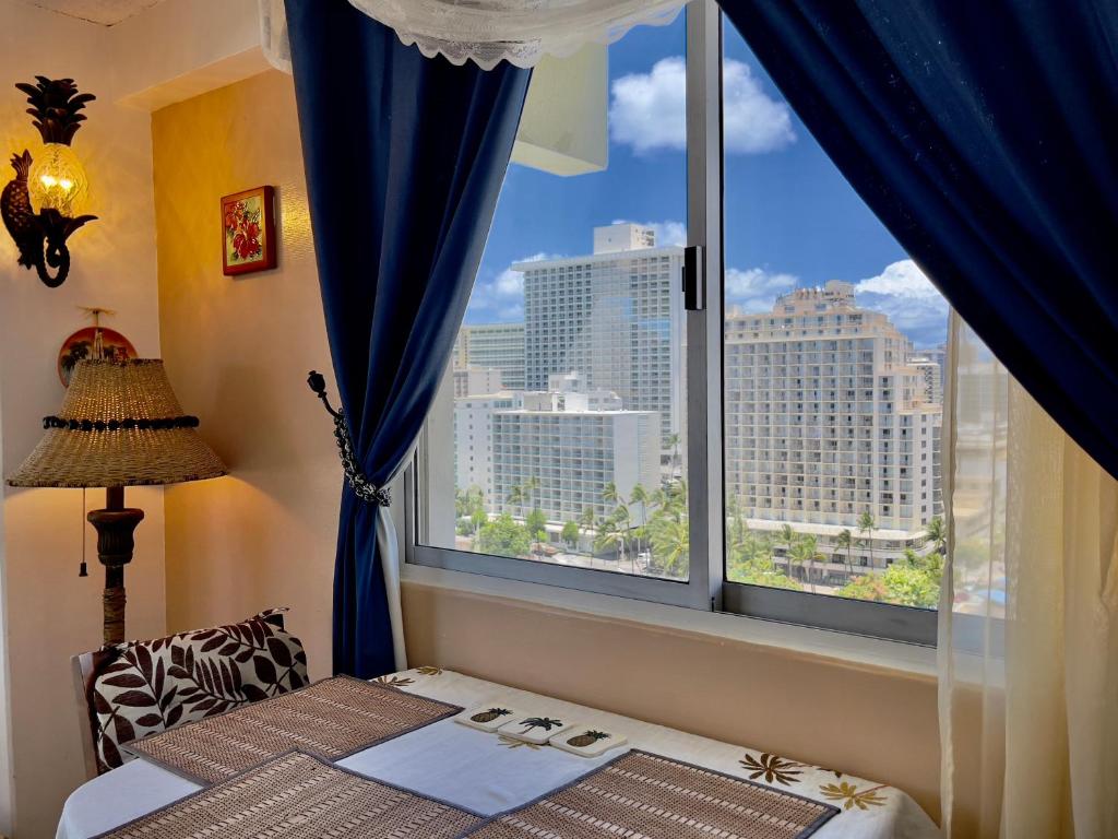 a bedroom with a window with a view of the city at Jenny's Pineapple Cottage in Honolulu