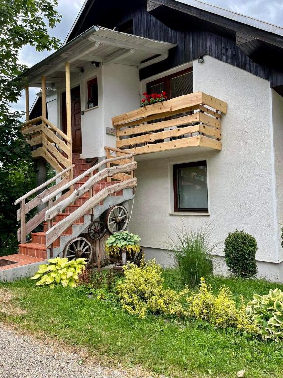a house with wooden stairs and a balcony at Apartma Pr'Toman in Kamna Gorica