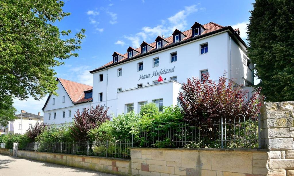un bâtiment blanc avec une clôture devant lui dans l'établissement Haus Hufeland, à Bad Salzungen