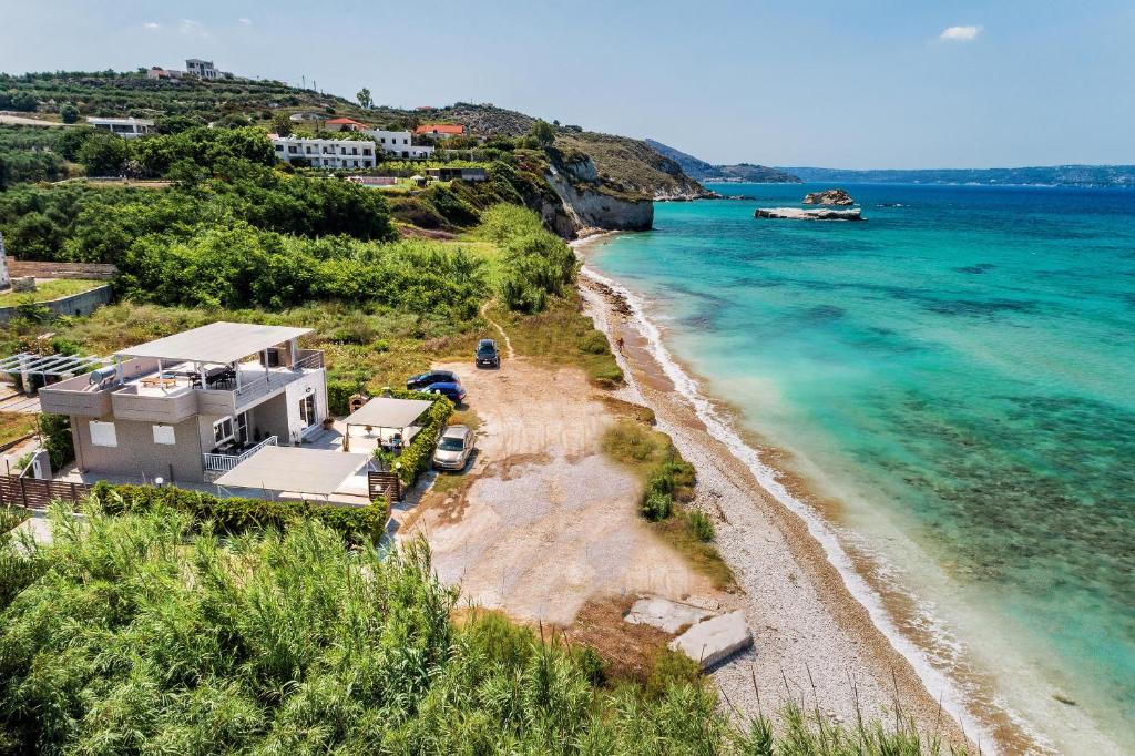 una casa en una playa con un barco en el agua en Grekodes Kera, seafront villa, en Kalyves