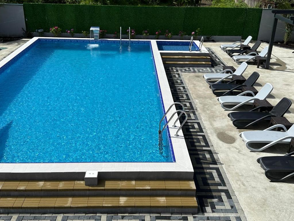 a swimming pool with lounge chairs next to it at Hotel Lion in Ureki