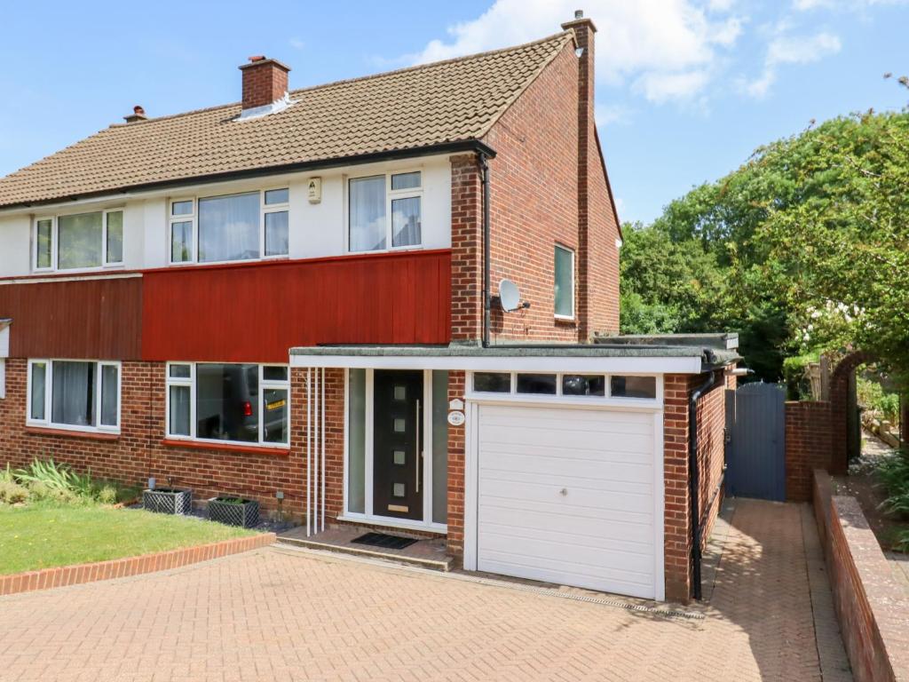 a brick house with a white garage at The Blossom Woods in High Wycombe