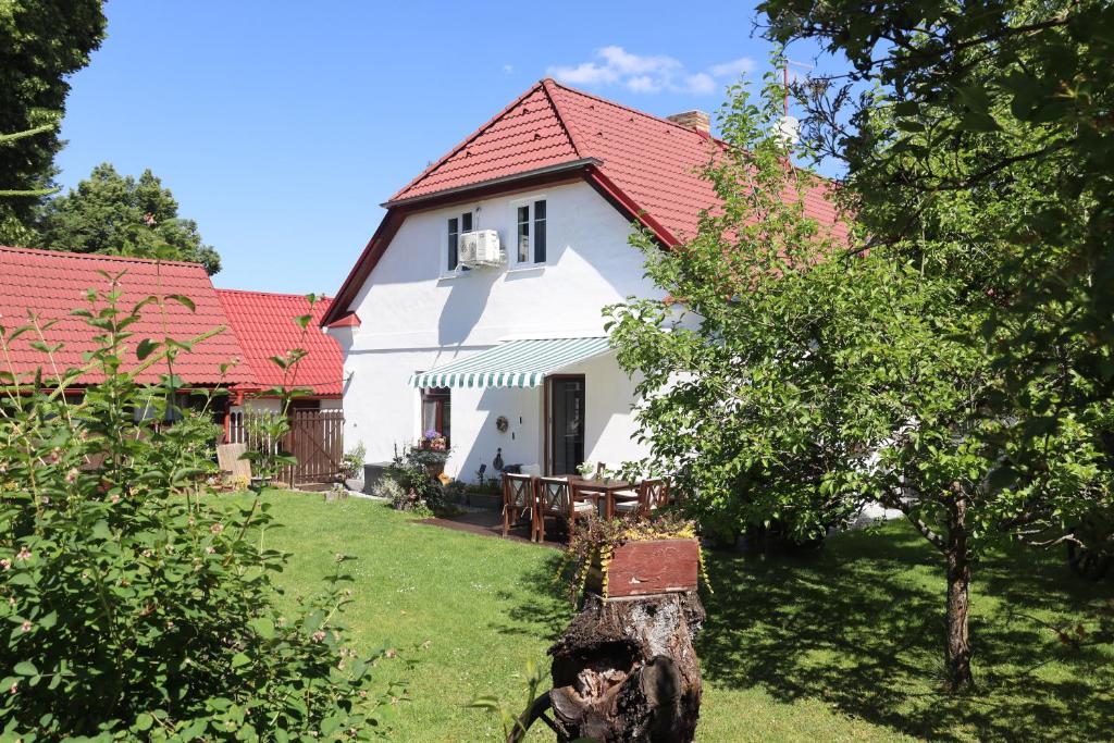 une maison blanche avec un toit rouge dans l'établissement ABC apartments, à Černá v Pošumaví