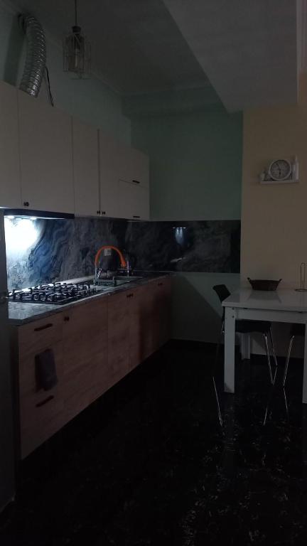 a kitchen with a stove and a sink and a table at Natia rooms in Tbilisi City