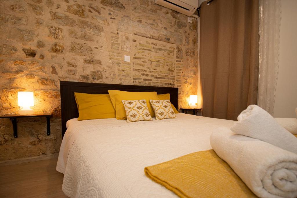 Un dormitorio con una cama grande con almohadas amarillas. en The Monastery Apartment, en Corfú
