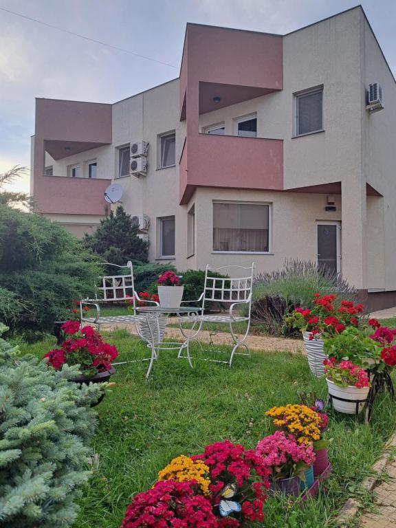 a building with benches and flowers in front of it at Vila Ambient frontal la mare in Mamaia Sat/Năvodari