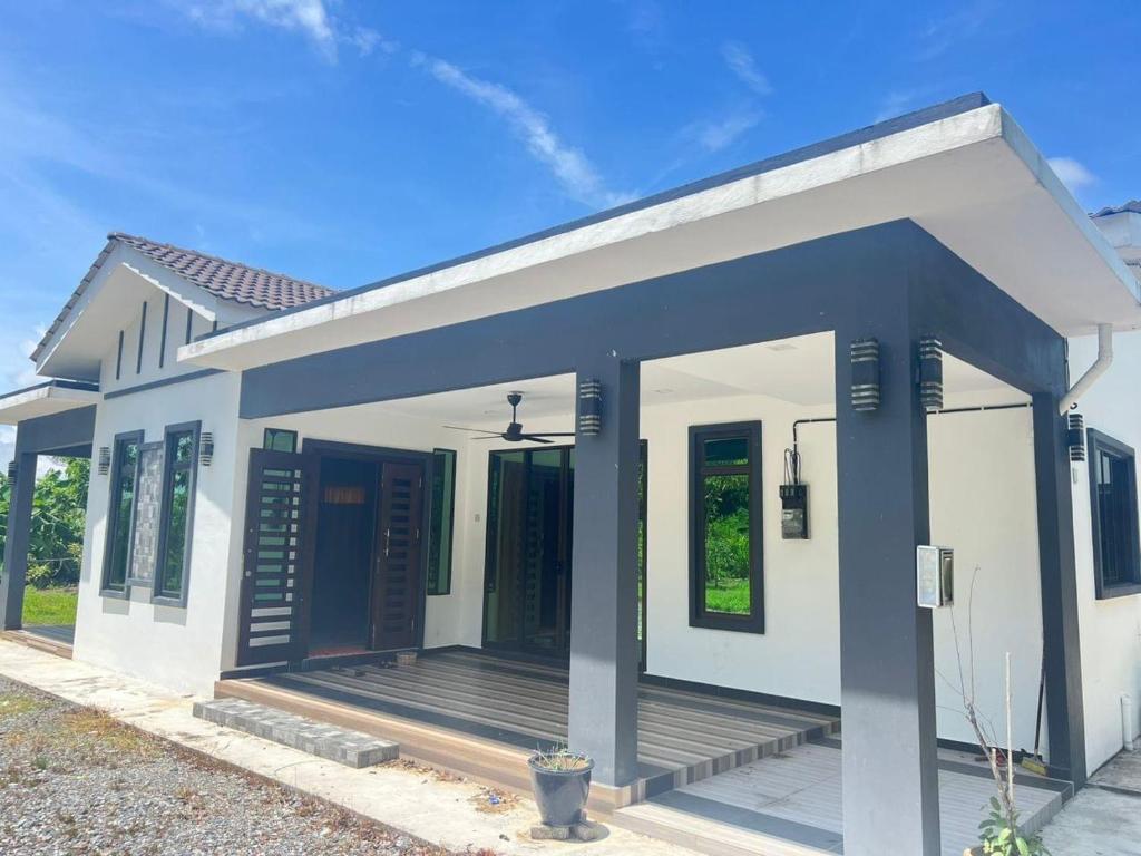 ein kleines weißes Haus mit blauem Dach in der Unterkunft Aimy’s Homestay in Simpang Empat