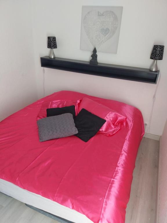 - une chambre avec un lit rose et 2 lampes dans l'établissement CHARMANT STUDIO VILLAGE NATURISTE CAP AGDE, au Cap d'Agde
