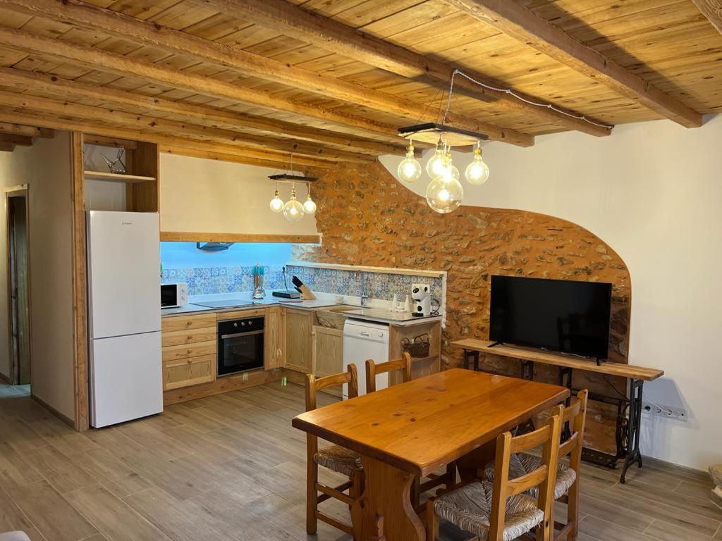 cocina con mesa de madera y nevera blanca en Casa Vicent, en Alcanar